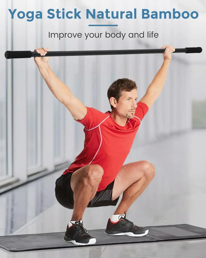 Man using a Yoga Stick Natural Bamboo product for exercise on a mat.