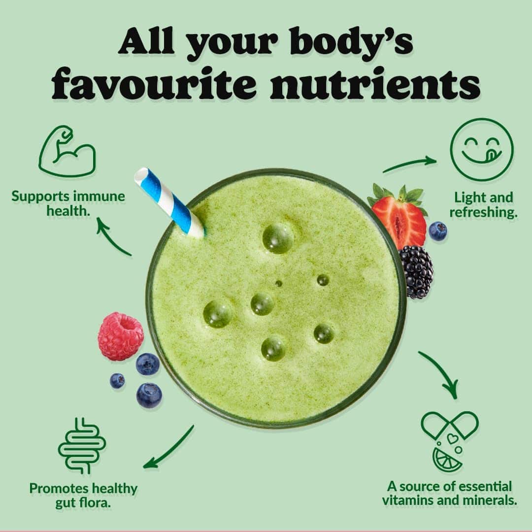 Green smoothie with berries and a straw on a light green background, promoting health benefits.