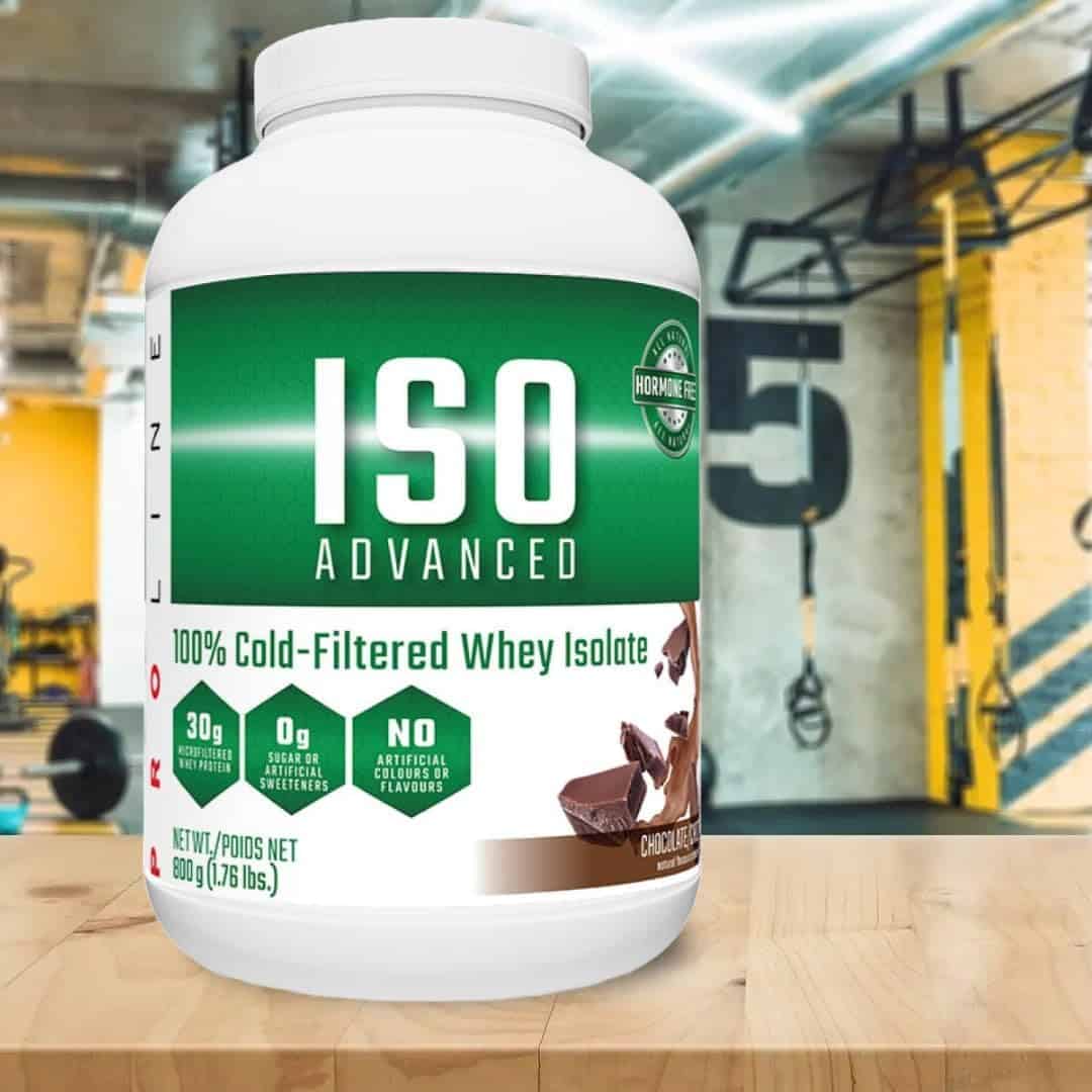 Container of ISO Advanced whey isolate powder in a gym setting