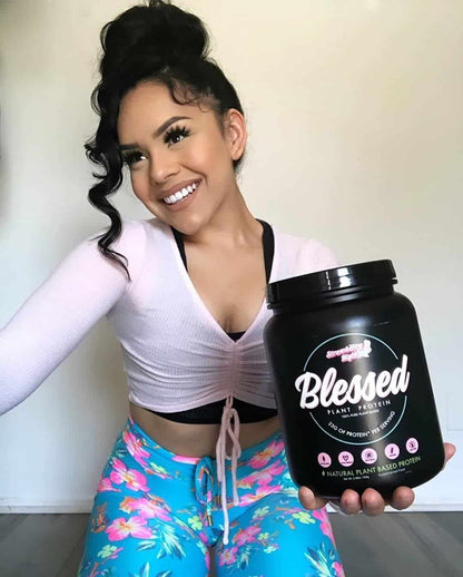 Woman holding a 'Blessed' protein powder container against a neutral background