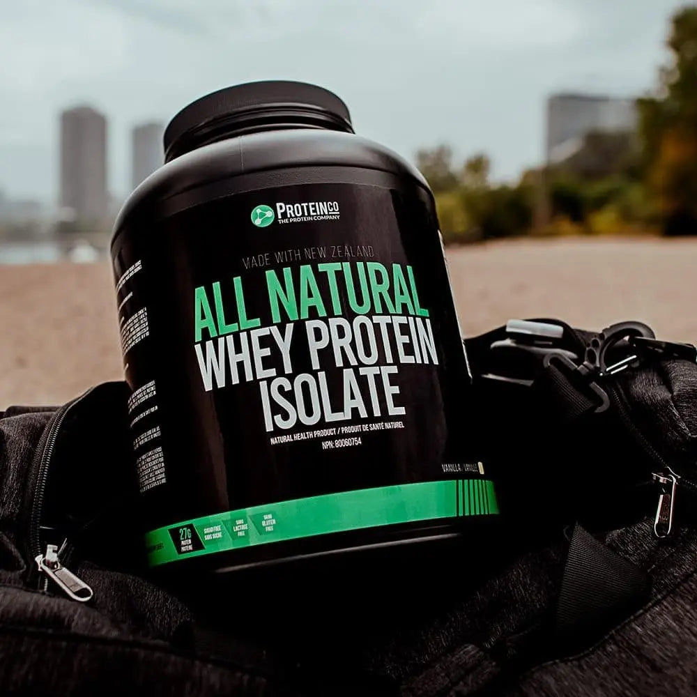 Protein supplement container labeled 'All Natural Whey Protein Isolate' on a black bag with a blurred outdoor background.