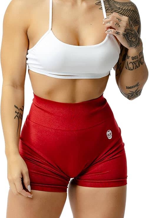 Person wearing a white sports bra and red shorts on a white background