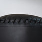 Close-up of black leather with visible stitching on a gray background