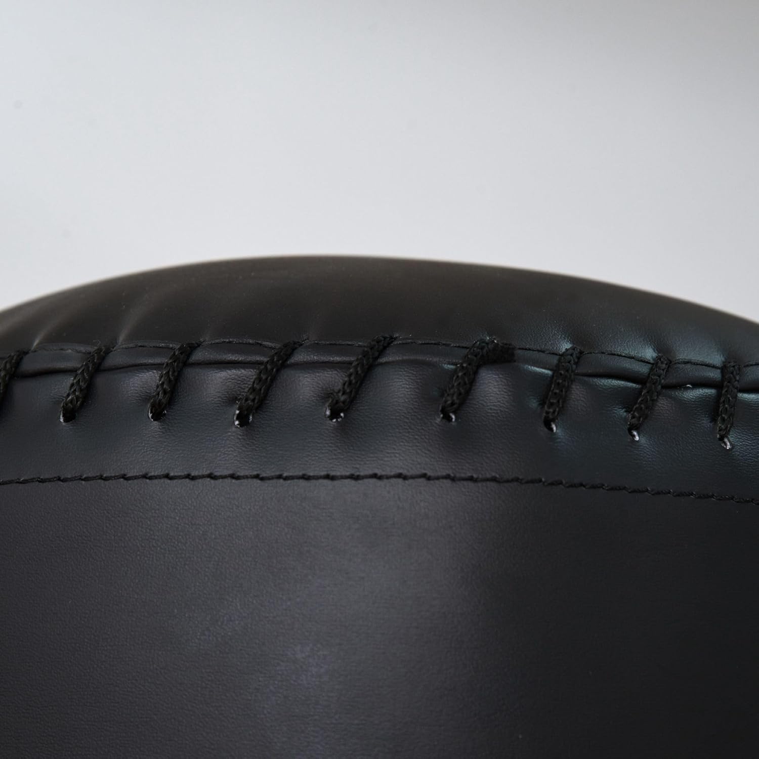 Close-up of black leather with visible stitching on a gray background