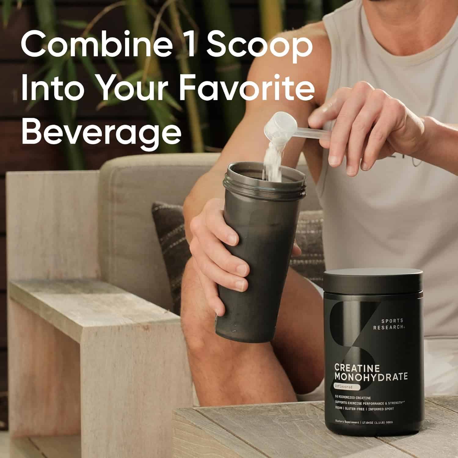 Person adding creatine monohydrate powder to a tumbler with text overlay.