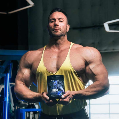 Muscular man holding a supplement container in a gym setting