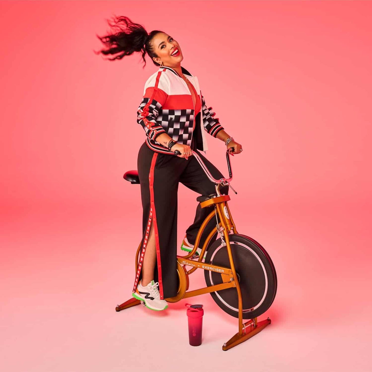 Woman on a bicycle against a pink background