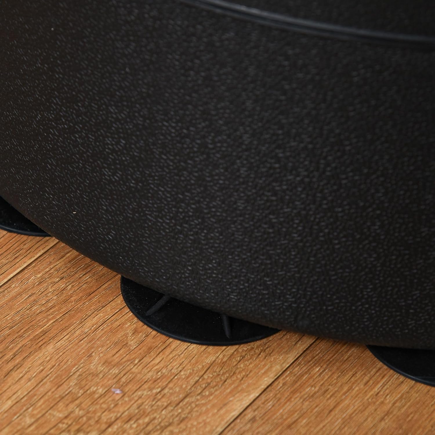 Close-up of a black textured object on a wooden floor