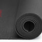 Rolled-up black yoga mat with a brand logo on a white background