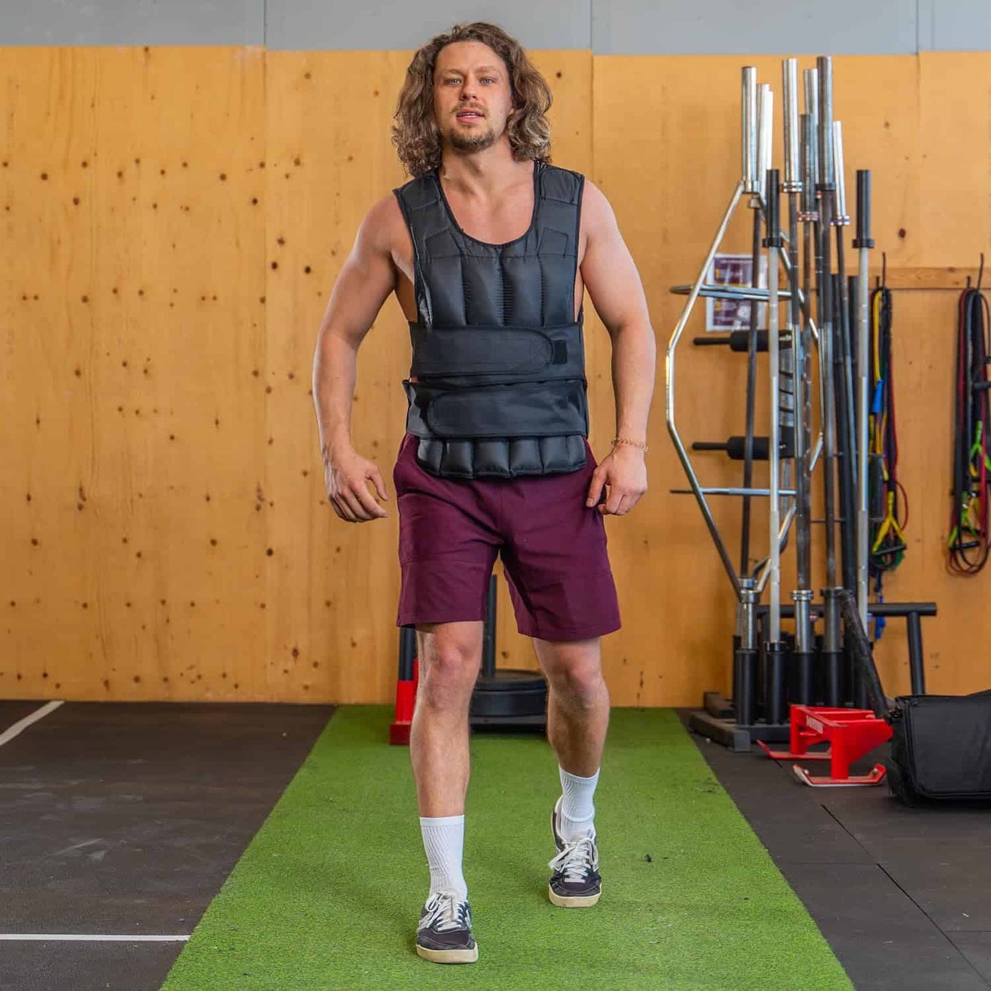 Man wearing a weighted vest in a gym setting