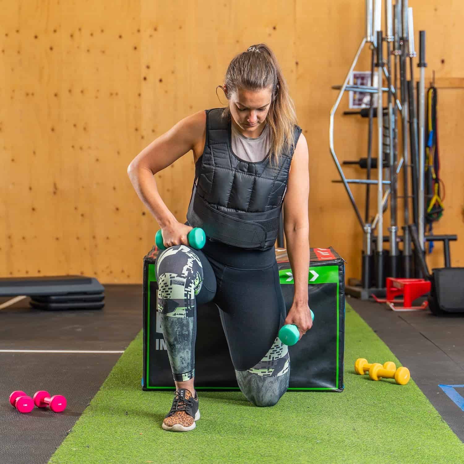 Woman exercising with dumbbells in a gym setting