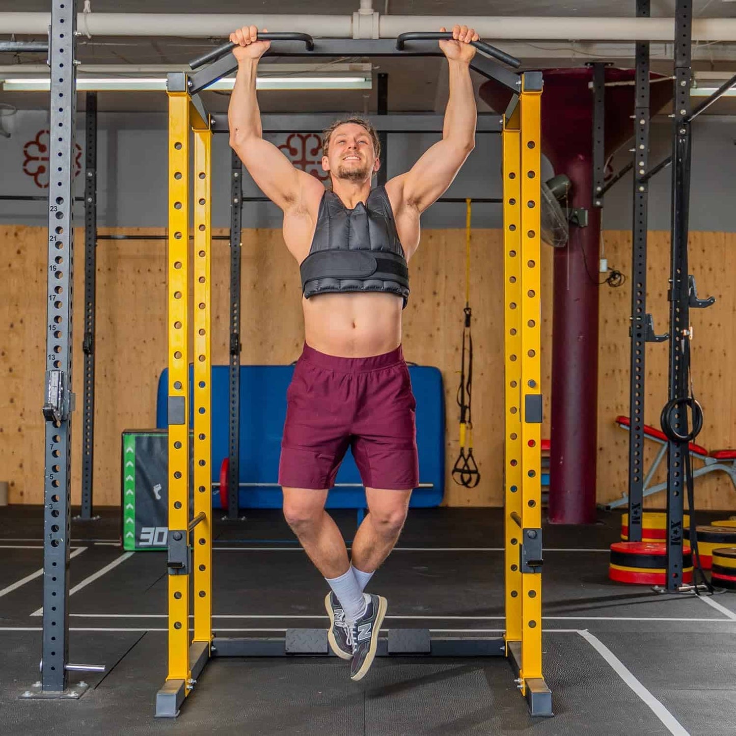 Man performing pull-ups on a pull-up bar in a gym setting