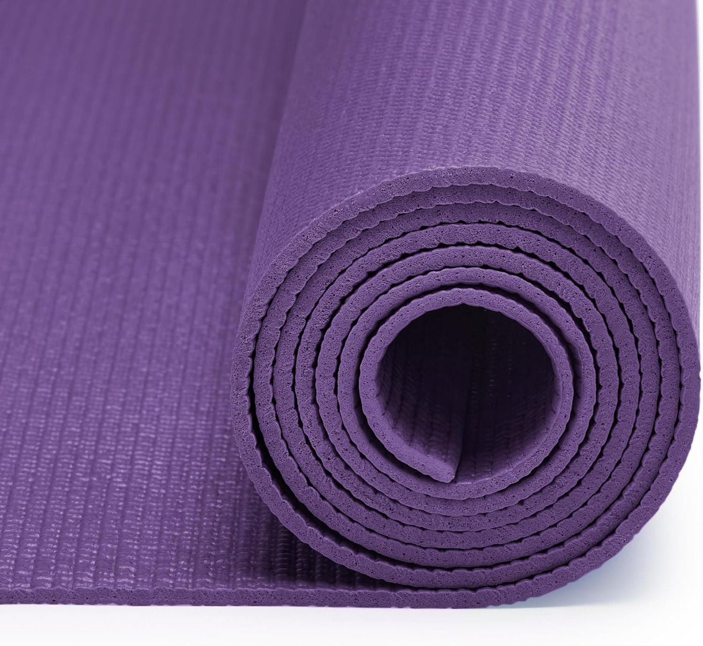 Purple yoga mat rolled up on a white background
