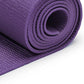 Purple yoga mat rolled up on a white background