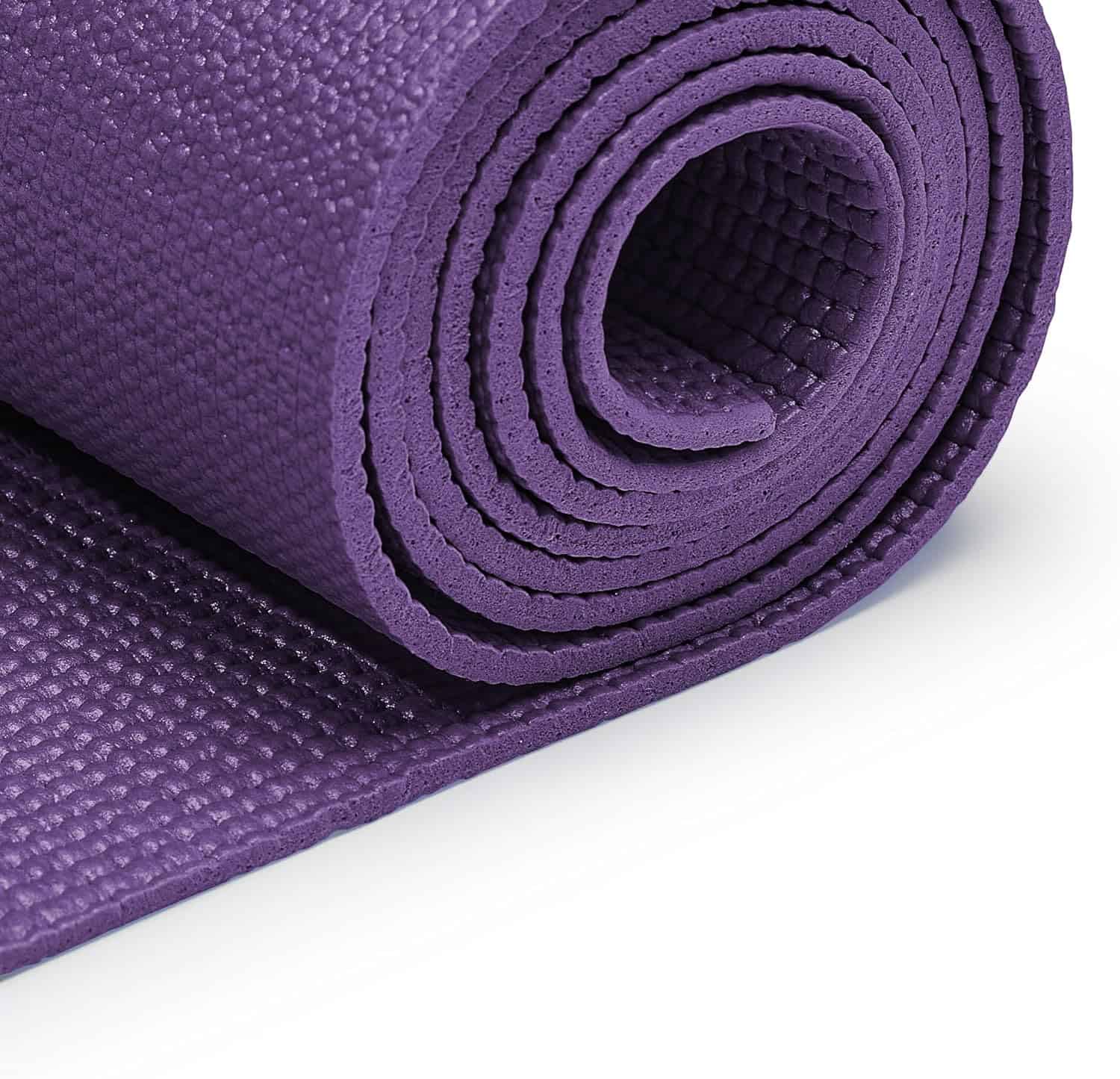 Purple yoga mat rolled up on a white background