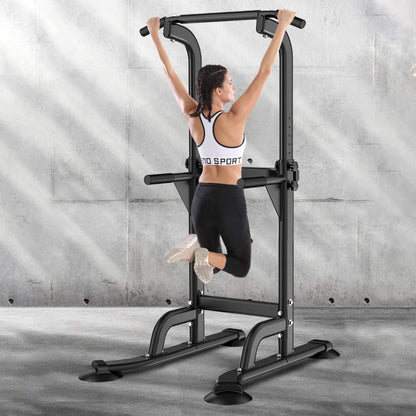 Woman exercising on a black pull-up bar against a gray concrete wall.