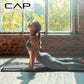Woman practicing yoga in a studio with 'CAP' branding.