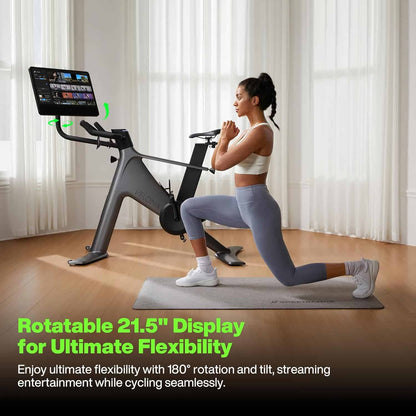 Woman exercising on a stationary bike with a rotatable display in a bright room.