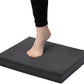 Person standing on a black footrest with a white background